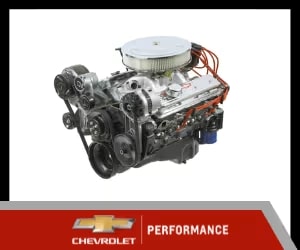 Chevrolet performance engine with polished aluminum intake and multiple pulleys, showcasing advanced automotive engineering and design.