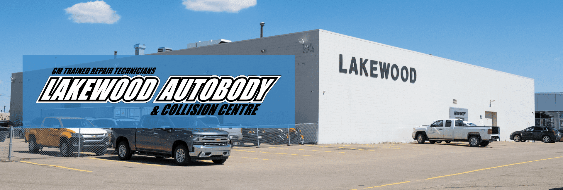 Image of Lakewood Autobody and Collision Centre, showcasing a modern facility with GM trained repair technicians. The exterior features multiple parked vehicles, including trucks and cars, under a clear blue sky, emphasizing the center's role in auto body repair and collision services.