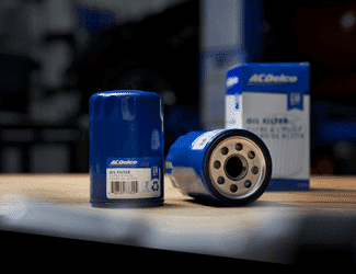 ACDelco oil filter with packaging displayed on a wooden surface, designed for effective engine protection and performance in vehicles.