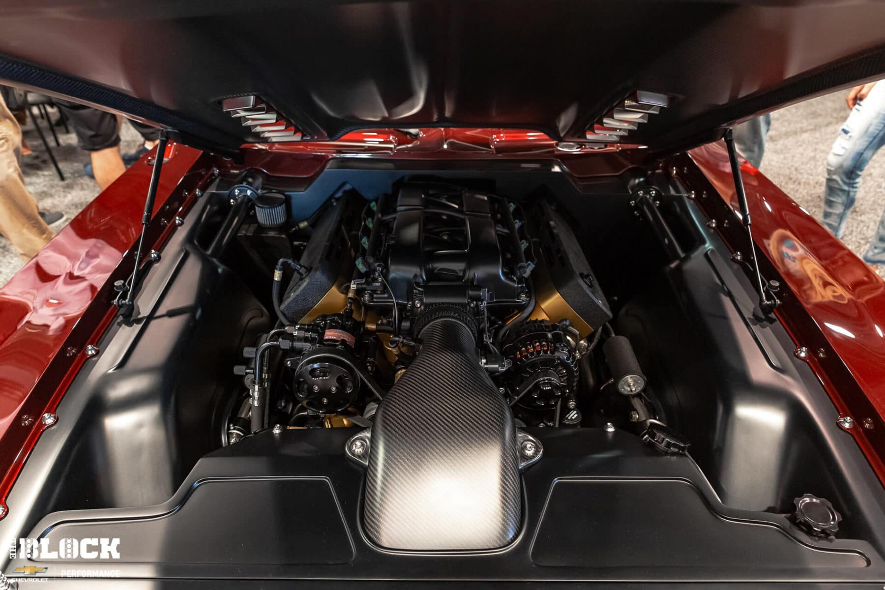 Black muscle car performing a burnout on a racing track, generating smoke and showcasing its powerful rear-wheel drive capabilities. The vehicle features stylish alloy wheels and an aerodynamic body, emphasizing its performance-focused design.